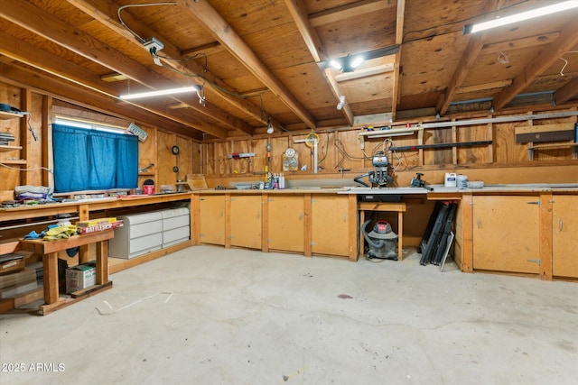 misc room featuring a workshop area and unfinished concrete flooring
