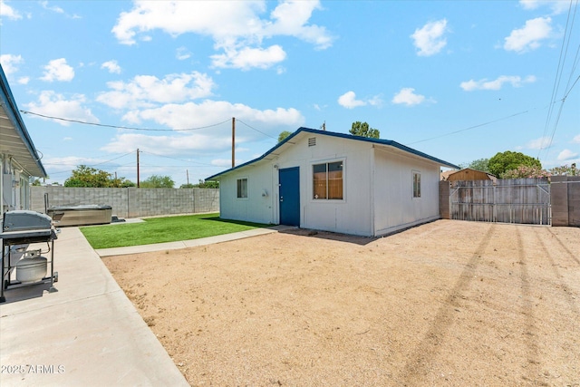 rear view of house with a patio area and a hot tub
