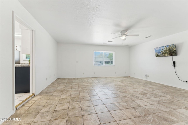spare room featuring a ceiling fan and light tile patterned floors