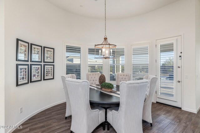 dining area featuring a healthy amount of sunlight, dark hardwood / wood-style floors, and a notable chandelier