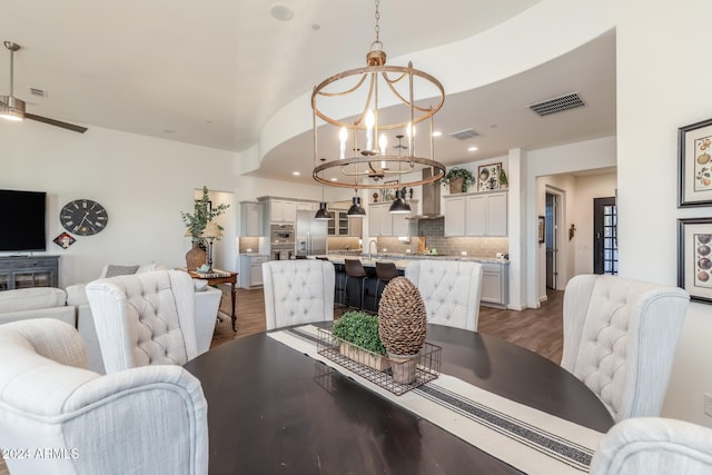 dining area featuring dark wood-type flooring and ceiling fan with notable chandelier