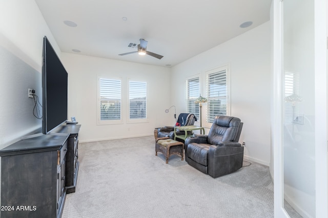 living area featuring ceiling fan and light colored carpet