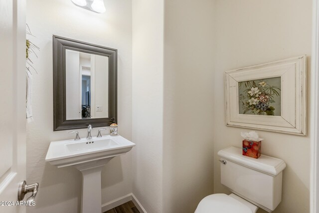 bathroom with hardwood / wood-style floors and toilet