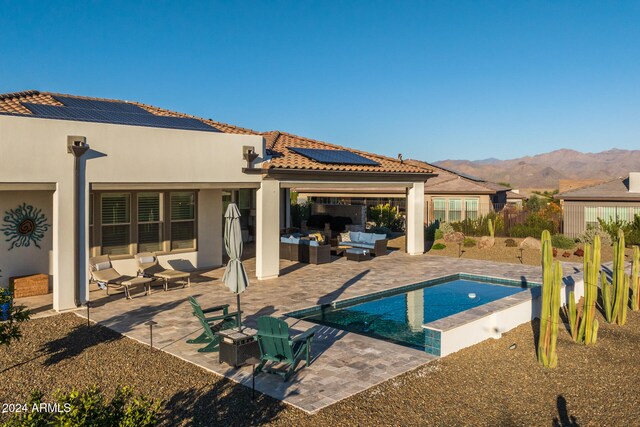 view of swimming pool featuring outdoor lounge area, a mountain view, and a patio area