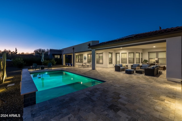 pool at dusk with an outdoor living space and a patio