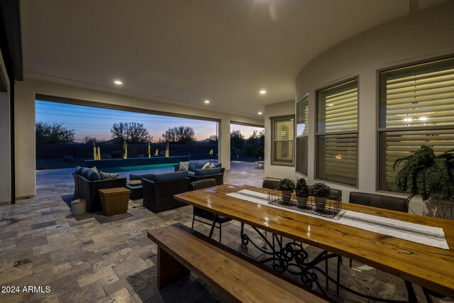 patio terrace at dusk with outdoor lounge area and a swimming pool