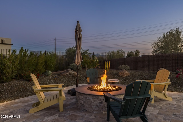 patio terrace at dusk featuring an outdoor fire pit