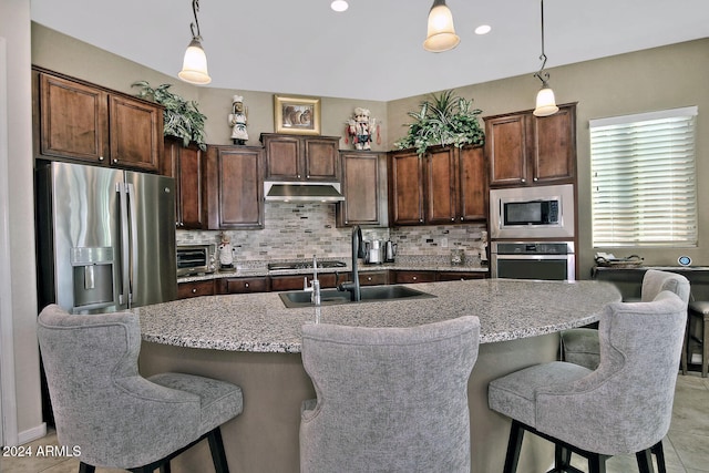 kitchen featuring decorative light fixtures, stainless steel appliances, dark brown cabinets, and sink