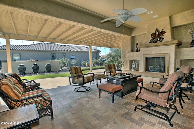 view of patio / terrace with an outdoor living space with a fireplace and ceiling fan