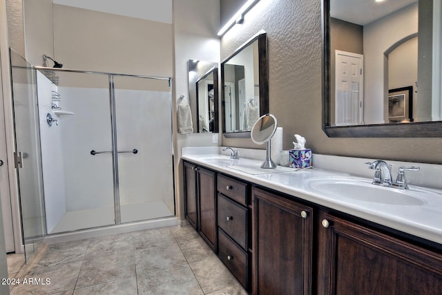 bathroom featuring tile patterned flooring, vanity, and a shower with shower door