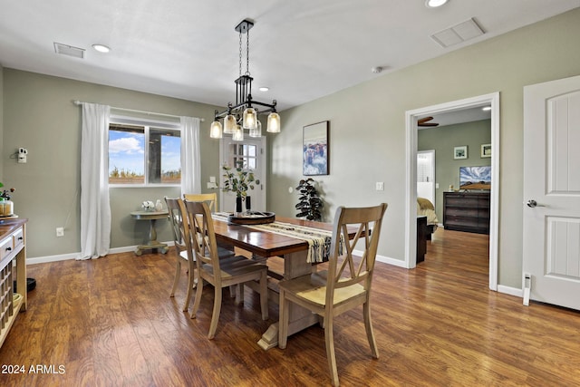 dining room featuring dark wood-type flooring and a chandelier