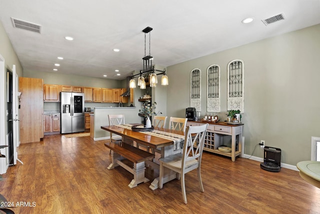 dining space with hardwood / wood-style flooring and an inviting chandelier