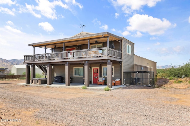 view of front facade with a patio, a deck with mountain view, and ceiling fan