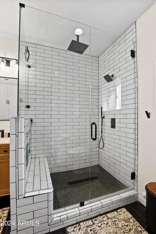 bathroom with vanity and a shower with door