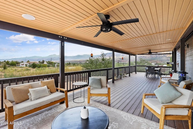 deck featuring a mountain view, outdoor lounge area, and ceiling fan