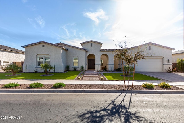 mediterranean / spanish-style home with a front lawn and a garage