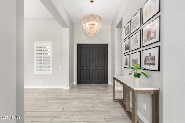 entryway with an inviting chandelier and light wood-type flooring