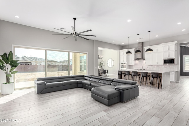 living room featuring ceiling fan and light hardwood / wood-style floors