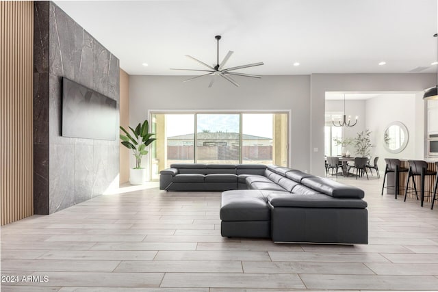 living room with ceiling fan with notable chandelier