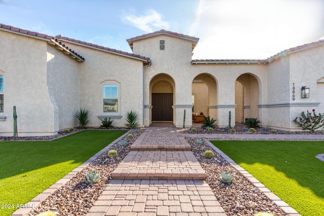 doorway to property featuring a lawn