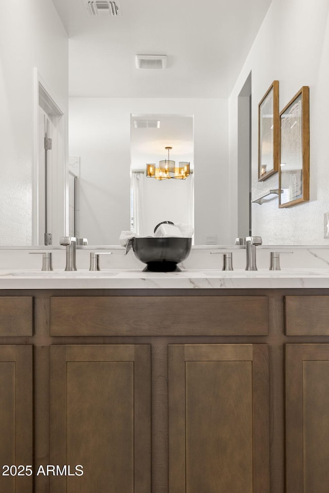 bathroom with vanity and an inviting chandelier