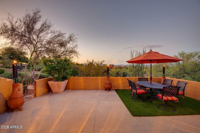 patio terrace at dusk with fence and a lawn