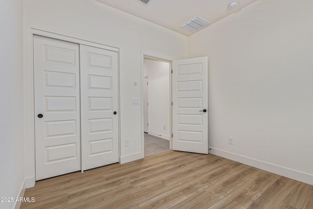 22876 E Via Del Sol, Queen Creek, AZ 85142 - unfurnished bedroom with light wood-style floors, a closet, and baseboards