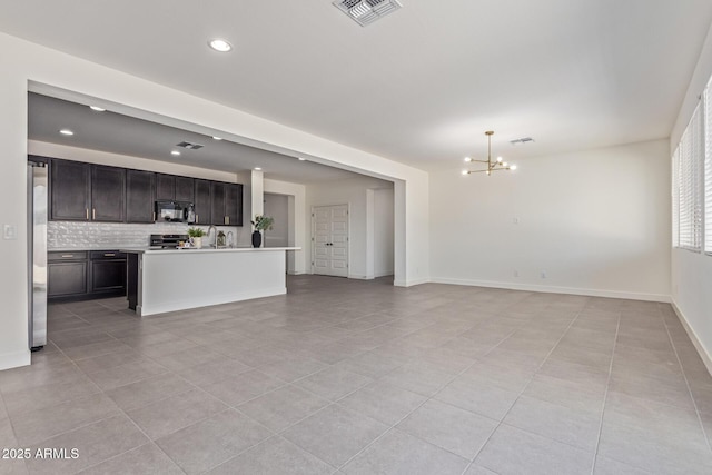 22876 E Via Del Sol, Queen Creek, AZ 85142 - unfurnished living room featuring a chandelier, light tile patterned floors, recessed lighting, baseboards, and a sink