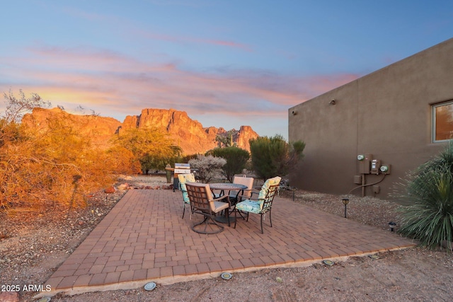 patio terrace at dusk featuring a mountain view