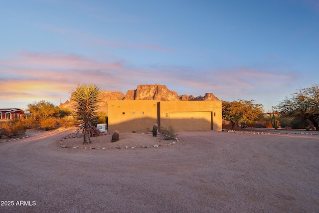 pueblo revival-style home featuring a garage