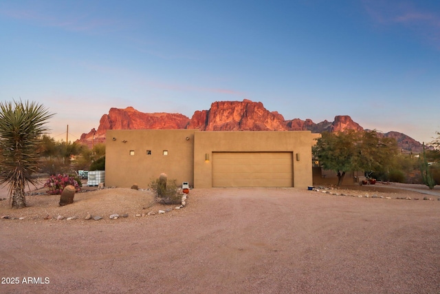 pueblo revival-style home featuring a mountain view and a garage