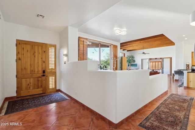 tiled foyer featuring ceiling fan and beamed ceiling