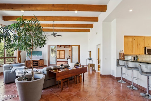 living room with ceiling fan, tile patterned floors, and beamed ceiling