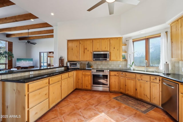 kitchen featuring stainless steel appliances, beam ceiling, tasteful backsplash, and sink