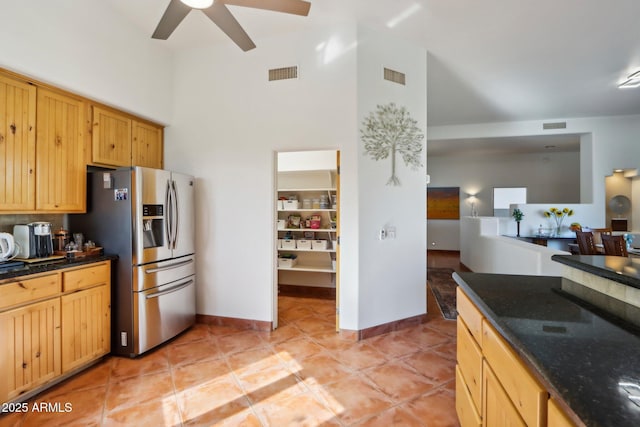 kitchen featuring ceiling fan, a high ceiling, light tile patterned floors, and stainless steel fridge with ice dispenser