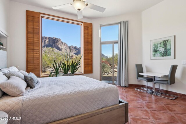 bedroom featuring ceiling fan, tile patterned flooring, and a mountain view