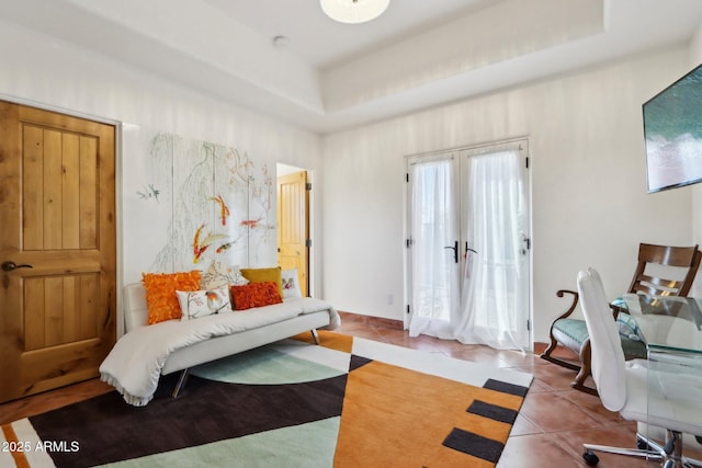 bedroom featuring a tray ceiling, french doors, and light tile patterned flooring