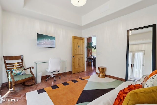 bedroom with tile patterned flooring and a tray ceiling