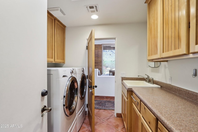 clothes washing area featuring cabinets, sink, light tile patterned floors, and separate washer and dryer