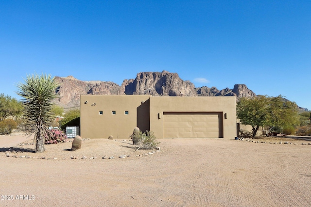 adobe home with a mountain view and a garage