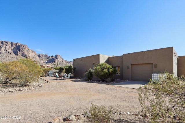 southwest-style home featuring a garage and a mountain view