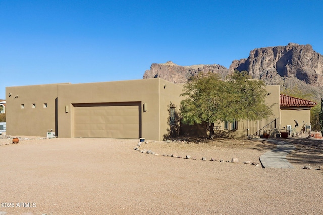 adobe home with a garage and a mountain view