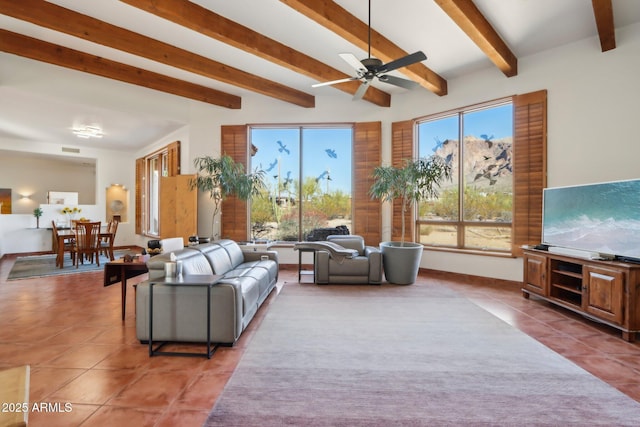 living room featuring ceiling fan, a wealth of natural light, and dark tile patterned flooring