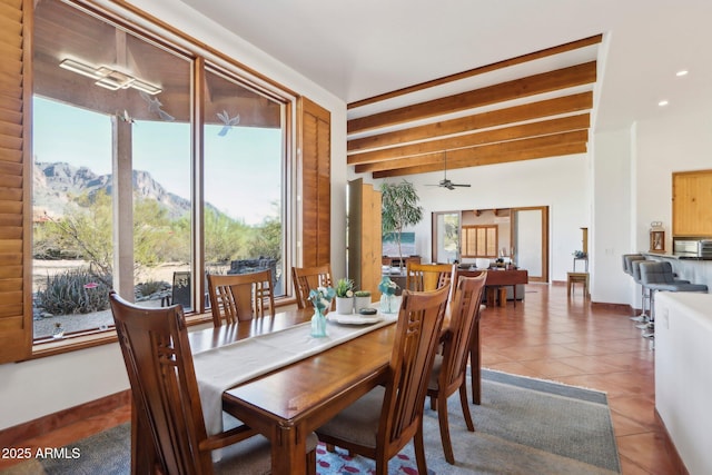 tiled dining area featuring ceiling fan, beamed ceiling, and a mountain view