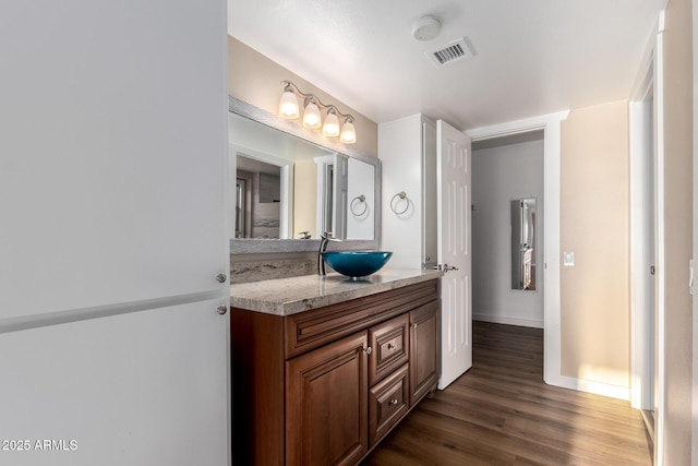 bathroom with wood finished floors, vanity, visible vents, and baseboards