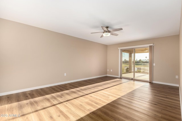 empty room with ceiling fan, baseboards, and wood finished floors