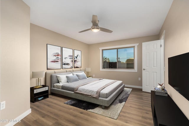 bedroom featuring ceiling fan, baseboards, and wood finished floors