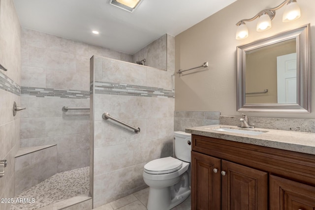 bathroom with tile patterned flooring, a walk in shower, tile walls, and vanity