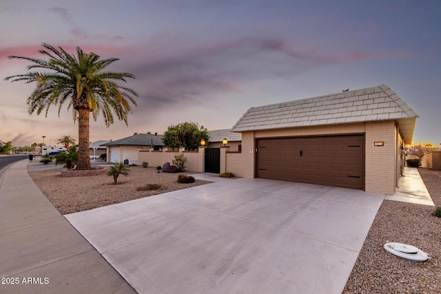 view of front of house with concrete driveway, brick siding, and an attached garage