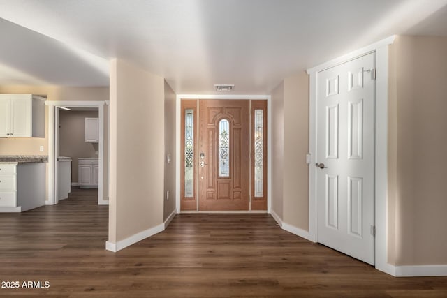 entrance foyer with baseboards, visible vents, and dark wood-type flooring